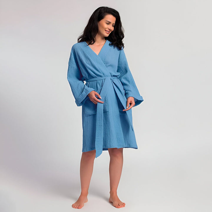Femme souriante portant un kimono bleu en coton. Peignoir confortable avec ceinture. Kimonos de bain et vêtements d'intérieur de qualité supérieure disponibles à l'achat.