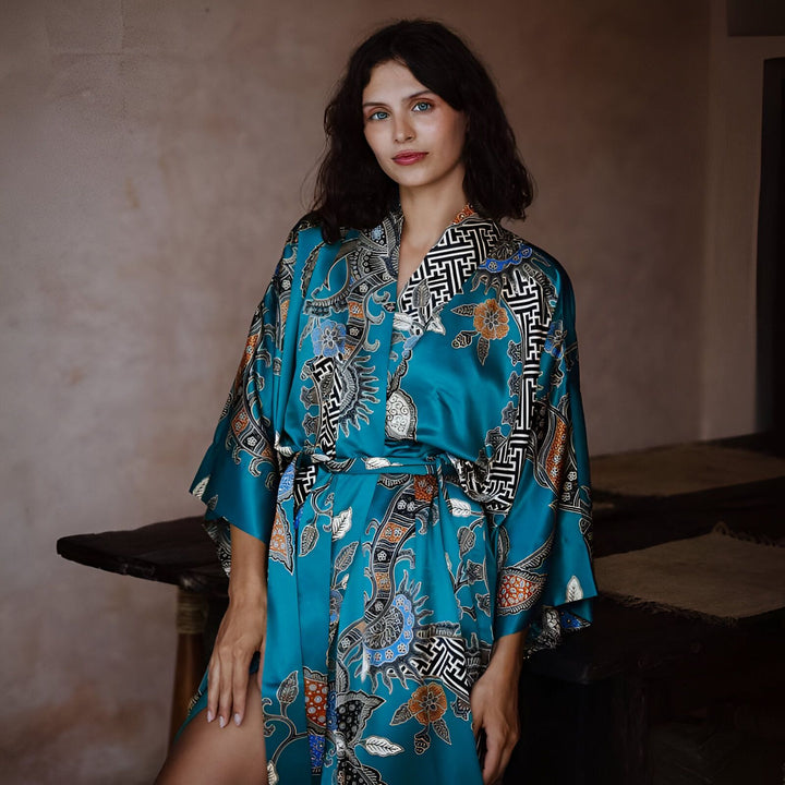 Femme portant un kimono bleu turquoise avec motifs floraux et géométriques. Vente de kimonos élégants.