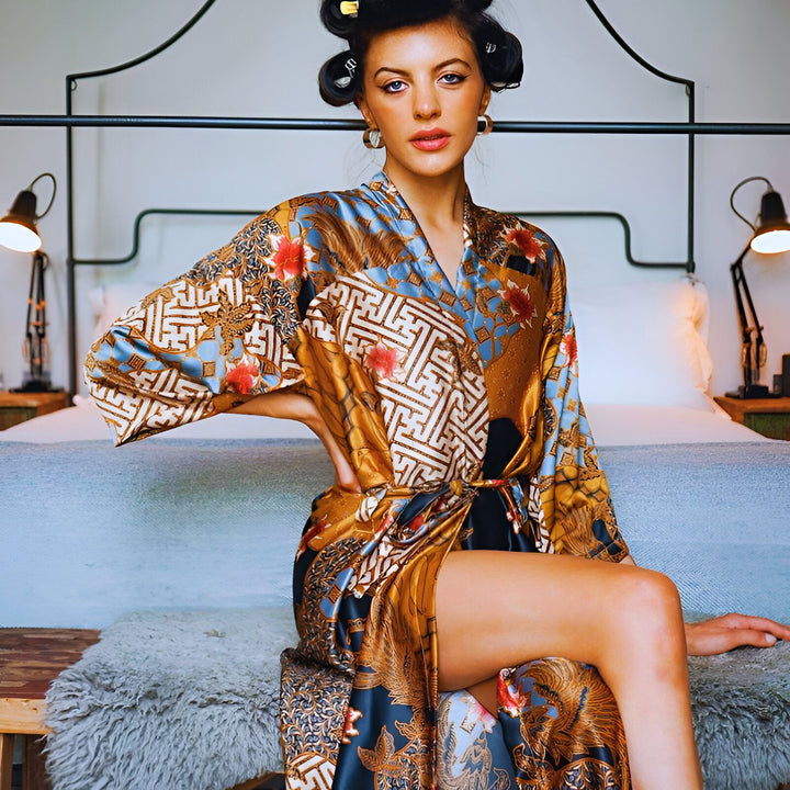 Femme élégante en kimono imprimé bleu, or et rouge. Vente de kimonos de qualité en ligne. Motif traditionnel, robe de chambre kimono, style japonais.