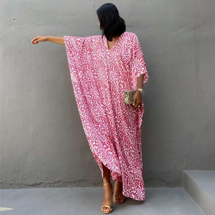 Femme portant un kimono long rose à motifs léopard. Vêtement ample et élégant. Mode kimono tendance.