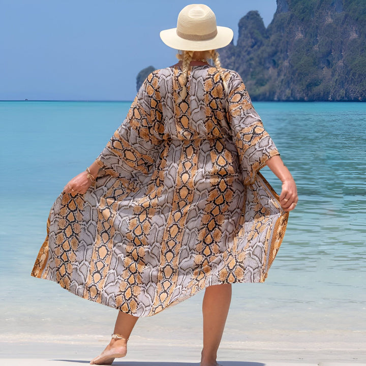 Femme portant un kimono motif serpent sur la plage. Kimonos élégants pour femmes. Découvrez notre collection de kimonos de plage, parfaits pour l'été.