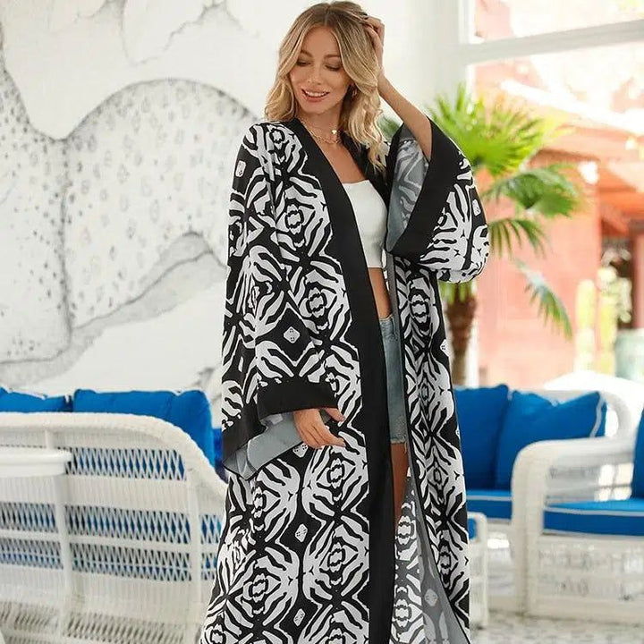 Femme portant un kimono à motifs noirs et blancs. Kimono tendance pour un look élégant et décontracté. Découvrez notre collection de kimonos.