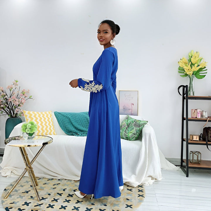 Femme souriante portant un kimono bleu roi brodé. Élégance et style japonais modernisé. Découvrez notre collection unique de kimonos.
