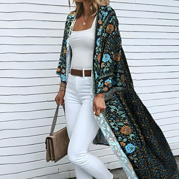 Femme portant un long kimono fleuri noir. Kimono à fleurs bleues et oranges, idéal pour un look bohème. Découvrez notre collection de kimonos pour femmes.