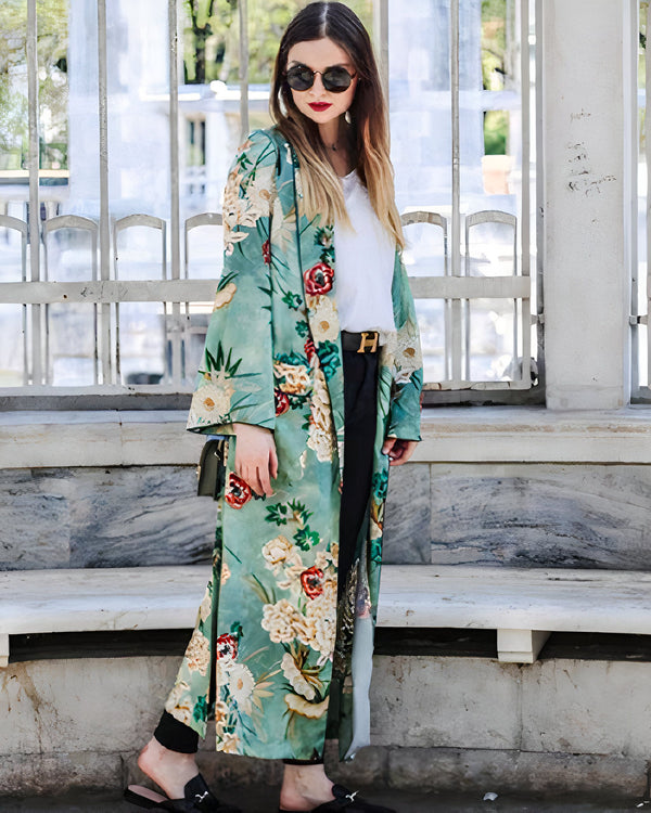 Femme portant un long kimono à motifs floraux, lunettes de soleil et ceinture. Kimonos chics et élégants à découvrir.