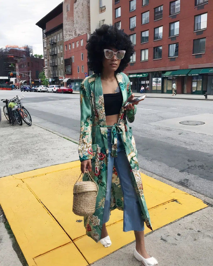 Femme en kimono fleuri vert dans la rue. Kimonos élégants pour toutes les occasions. Vêtements de détente chics et confortables. Découvrez notre collection de kimonos uniques.