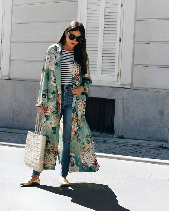 Femme portant un kimono long à motifs floraux, jean et haut rayé. Style décontracté et élégant. Notre collection de kimonos pour toutes les occasions.