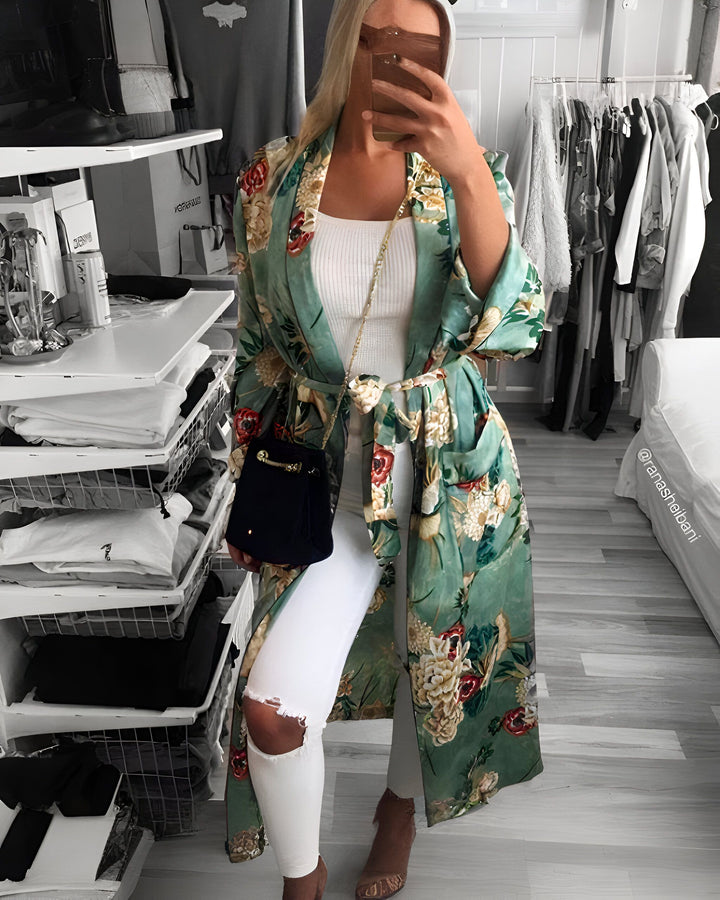 Femme posant avec un kimono fleuri vert et blanc, jean blanc déchiré et talons hauts. Parfait pour un look décontracté chic. Découvrez notre collection de kimonos uniques.