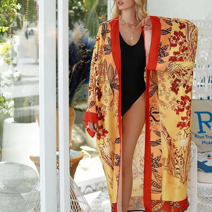 Femme portant un kimono jaune et orange à motifs floraux et animaux. Kimono élégant pour toutes occasions, disponible à l'achat. Découvrez notre collection de kimonos uniques.