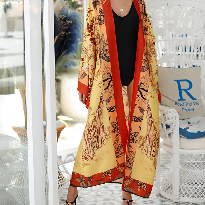 Femme portant un kimono long jaune et orange à motifs floraux, collection de kimonos pour femmes.