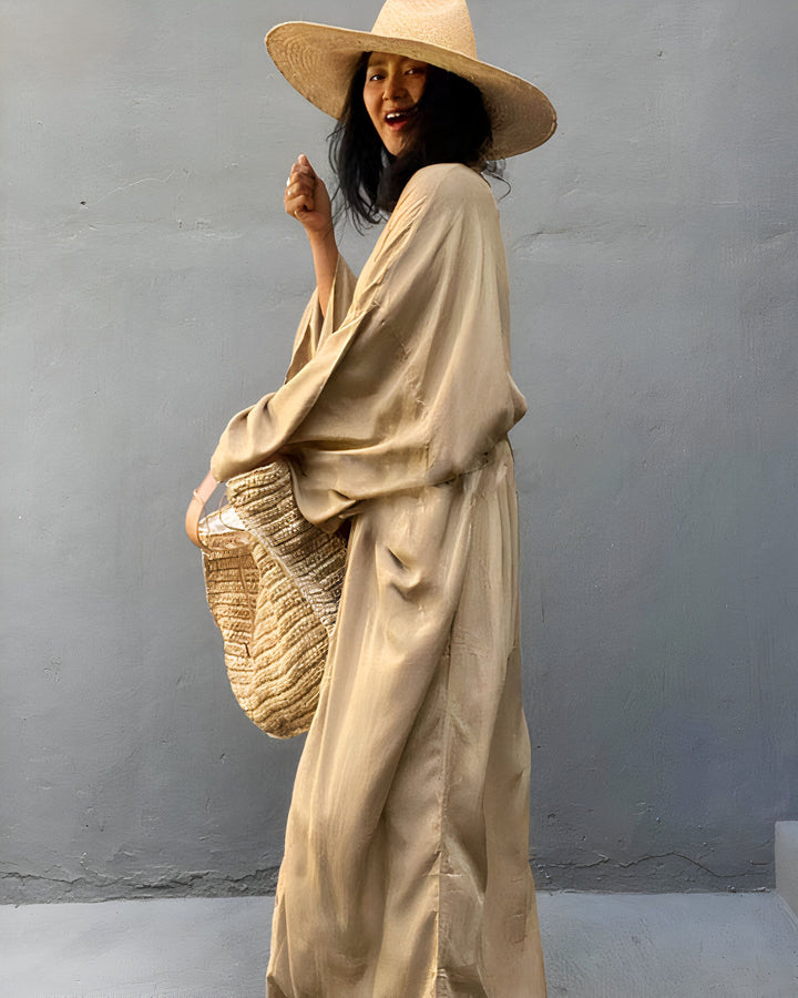 Femme souriante portant un kimono doré avec un chapeau de paille et un sac en osier. Vêtements de style japonais en vente. Mode kimono, style décontracté, kimono d'été.