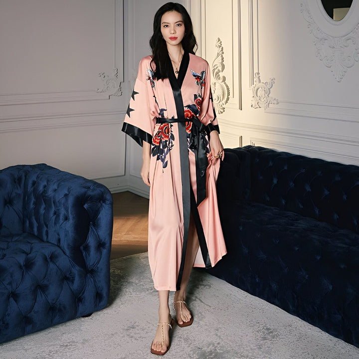 Kimono rose en satin avec imprimé floral et ceinture noire, parfait pour se détendre avec style. Découvrez notre collection de kimonos.