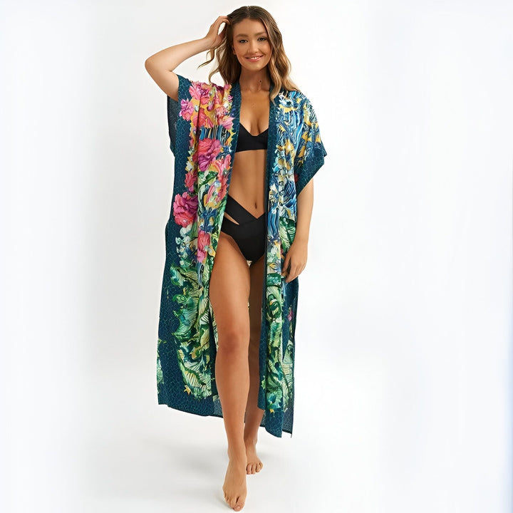 Femme souriante portant un kimono long bleu à motifs floraux. Vêtements d'été amples et légers. Kimonos de plage tendance disponibles en ligne.