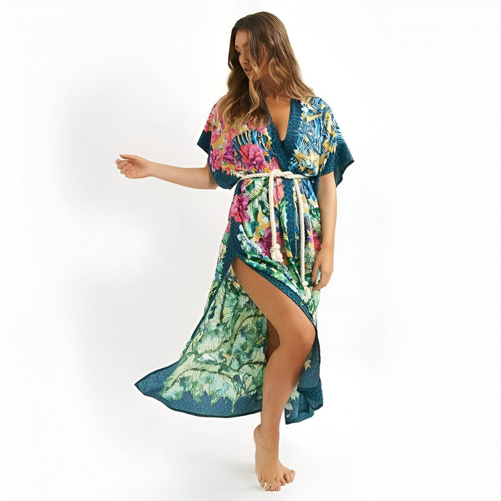 Femme portant un kimono long à motifs floraux tropicaux avec une ceinture en corde. Vêtement d'été idéal pour la plage ou la maison. Kimonos disponibles à l'achat.