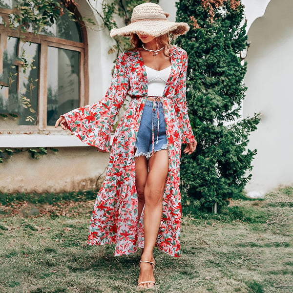 Femme portant un kimono long fleuri rouge et blanc, short en jean bleu, top blanc et chapeau de paille. Style bohème chic, idéal pour l'été. Boutique de kimonos en ligne.