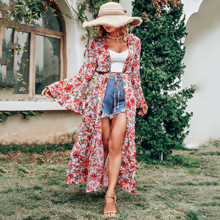 Femme portant un kimono long fleuri rouge et blanc, short en jean bleu, top blanc et chapeau de paille. Style bohème chic, idéal pour l'été. Boutique de kimonos en ligne.