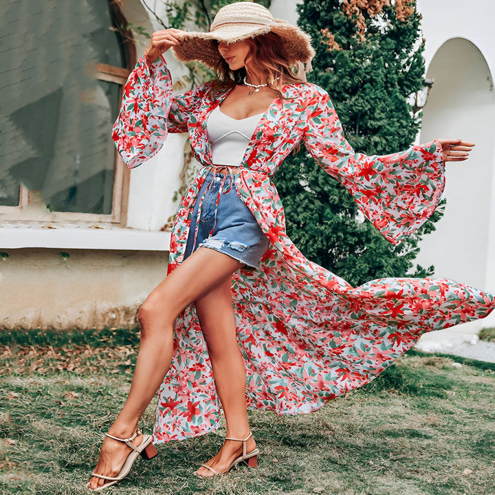 Femme portant un kimono long fleuri rouge et blanc, un short en jean et un chapeau de paille. Mode d'été, vêtements de plage. Notre collection de kimonos tendance.