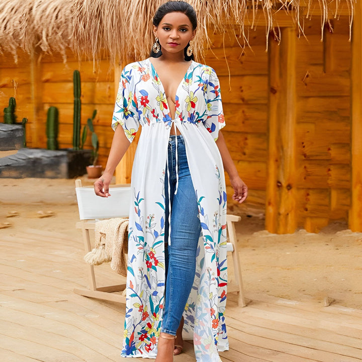 Femme portant un kimono long blanc à motifs floraux colorés. Vêtement léger et élégant, parfait pour l'été. Notre collection de kimonos pour femmes.