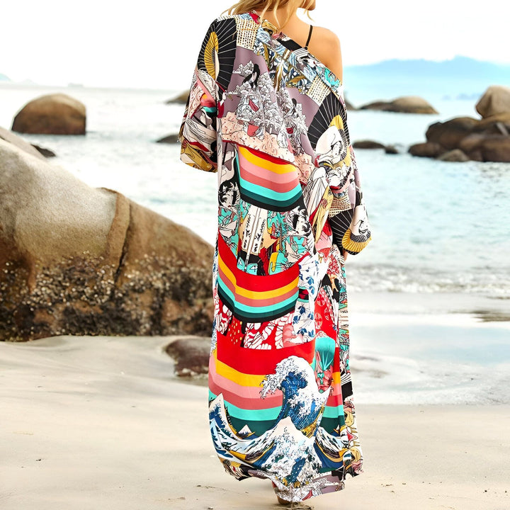 Femme portant un kimono long et coloré sur la plage. Le kimono présente des motifs japonais traditionnels et des rayures vives. Vêtements de plage, style bohème. Notre collection de kimonos.