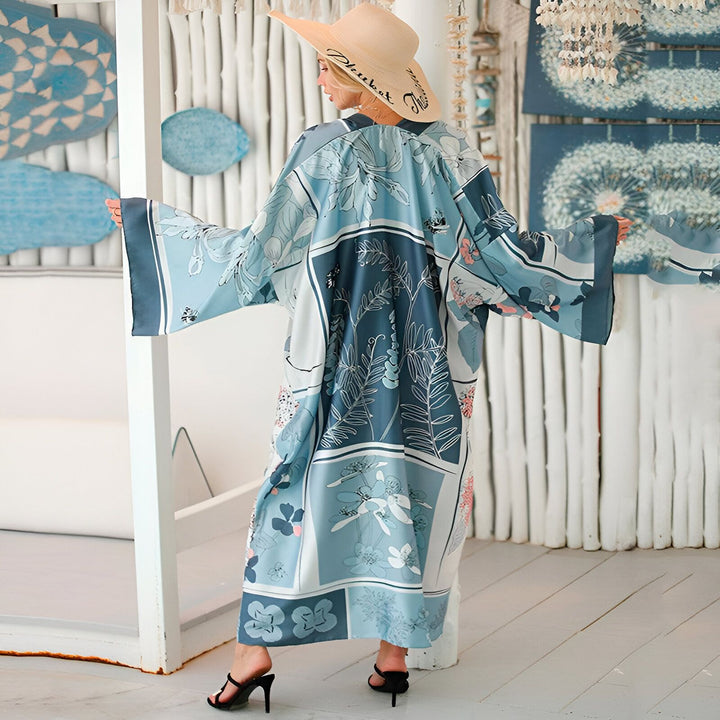 Femme portant un kimono long bleu et blanc à motifs floraux, avec un chapeau de paille. Kimonos de haute qualité à vendre.