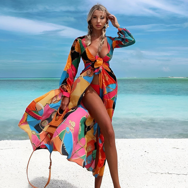 Femme sur la plage portant un kimono coloré. Vêtement de plage, kimono long à motifs vifs, mode estivale. Découvrez notre collection de kimonos pour un look bohème chic.