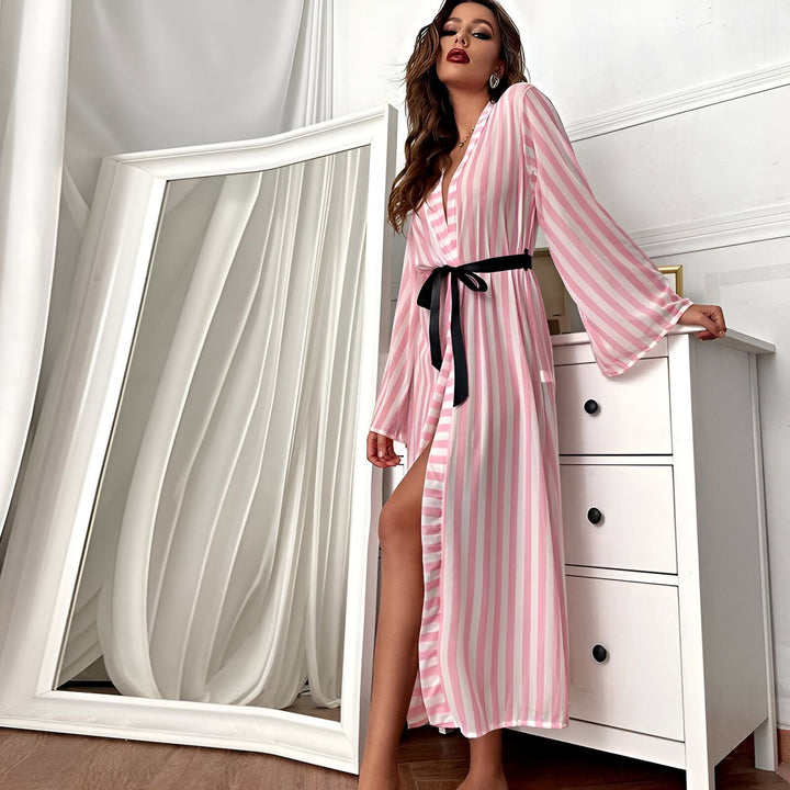 Femme portant un kimono long à rayures roses et blanches, ceinturé de noir. Notre collection de kimonos élégants et confortables.