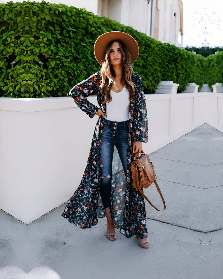Femme portant un long kimono à fleurs avec jean, sac en cuir et chapeau. Style bohème chic. Collection de kimonos pour femmes.