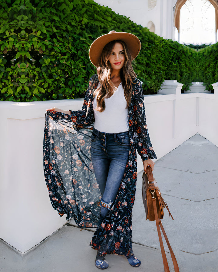 Femme portant un kimono long à imprimé floral, un jean, un chapeau et un sac en cuir. Vente de kimonos pour femmes en ligne.