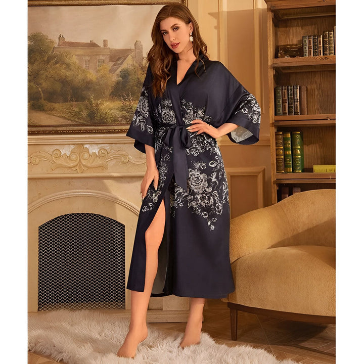 Femme portant un kimono long bleu marine avec imprimé floral. Kimono de notre collection, idéal pour se détendre avec style. Vêtements d'intérieur élégants et confortables.