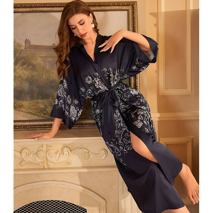 Femme portant un kimono bleu marine à motifs floraux. Peignoir élégant en soie, kimono de luxe pour la maison. Vêtements d'intérieur confortables et raffinés. Collection de kimonos exclusifs.