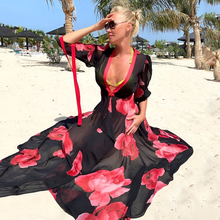 Femme portant un kimono fleuri noir et rouge sur une plage ensoleillée. Kimono léger et élégant pour l'été. Mode plage et vêtements d'extérieur.