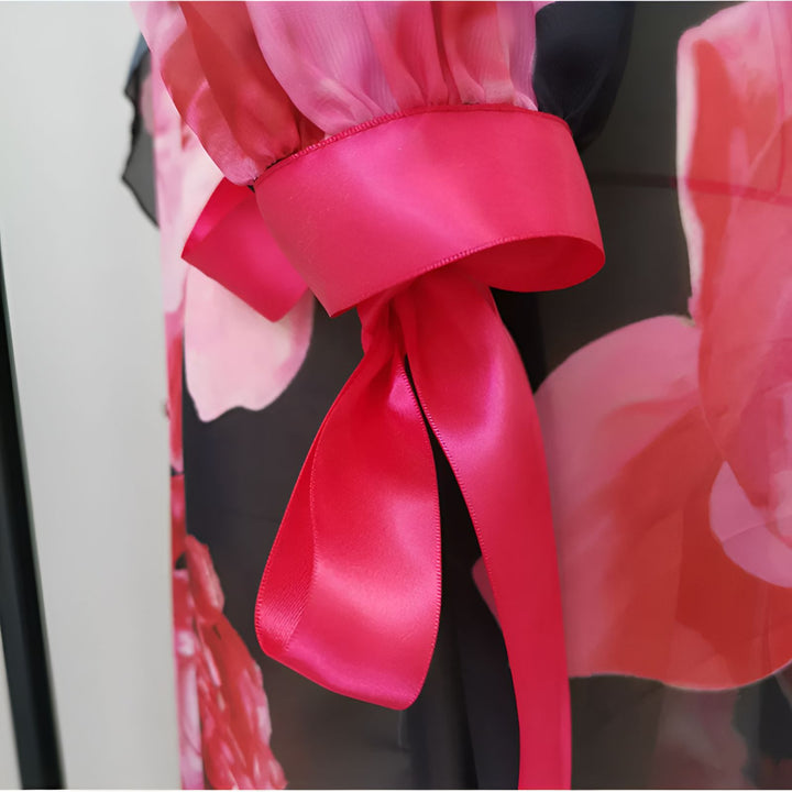 Détail d'un kimono fleuri avec une manche fuchsia à ruban. Kimono élégant et coloré disponible à l'achat.