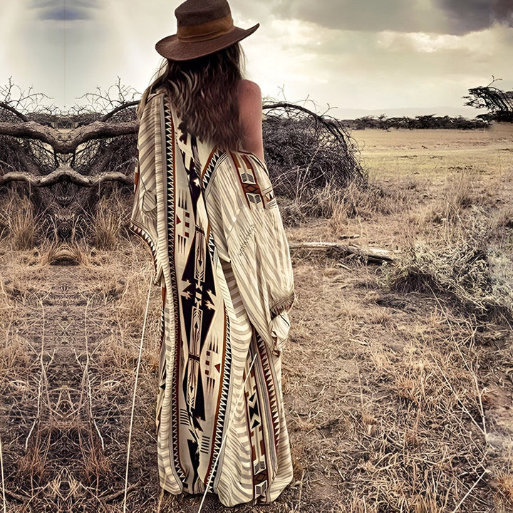 Femme portant un kimono à motifs ethniques et un chapeau dans un paysage aride. Kimonos pour femmes, vêtements bohèmes, style unique. Découvrez notre collection de kimonos.
