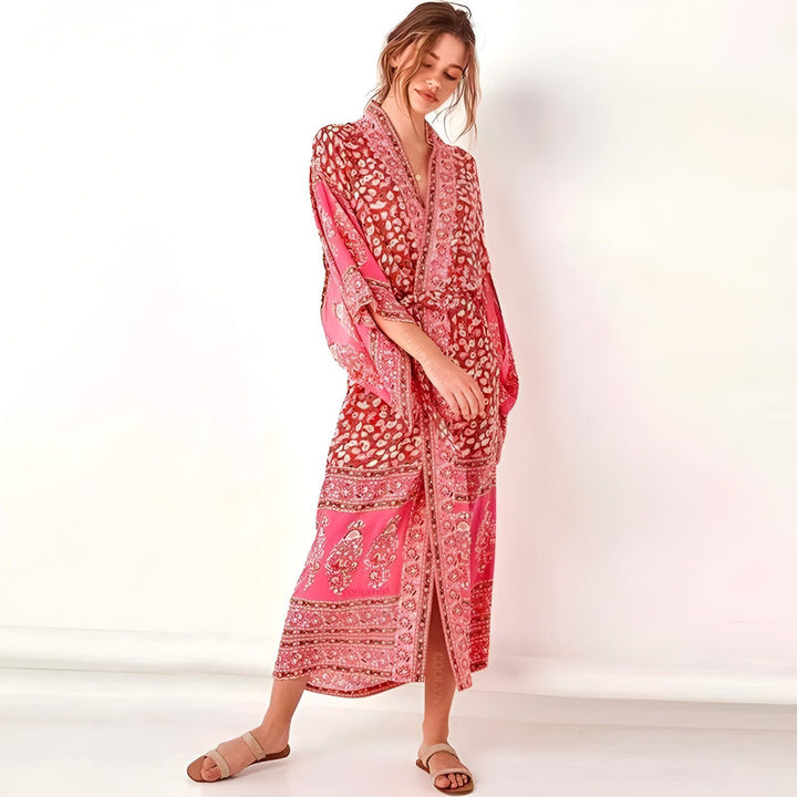 Femme portant un kimono long rose à motifs floraux. Kimono confortable et élégant pour toutes les occasions. Découvrez notre collection de kimonos.