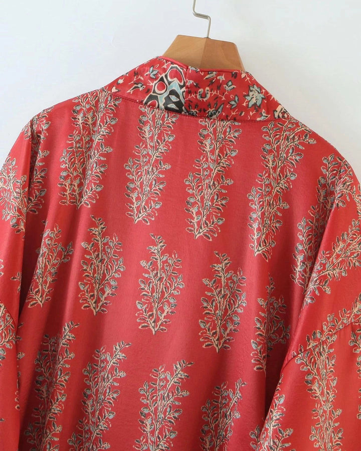 Kimono rouge à motifs floraux suspendu sur un cintre en bois. Vêtement de style japonais disponible à l'achat.