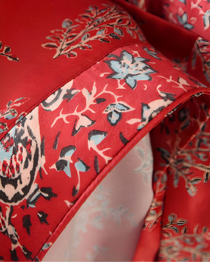 Détail de tissu rouge fleuri d'un kimono. Motifs floraux bleus et noirs sur fond rouge. Vente de kimonos en ligne.