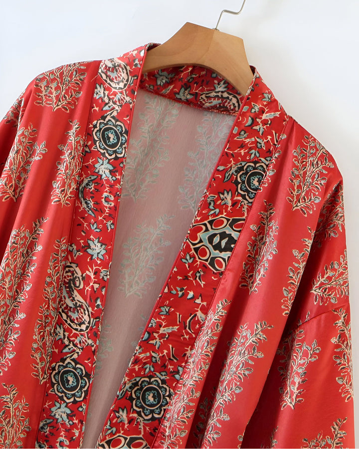 Kimono rouge à motifs floraux sur cintre en bois. Vêtement d'extérieur léger et élégant, parfait pour superposer. Découvrez notre collection de kimonos.