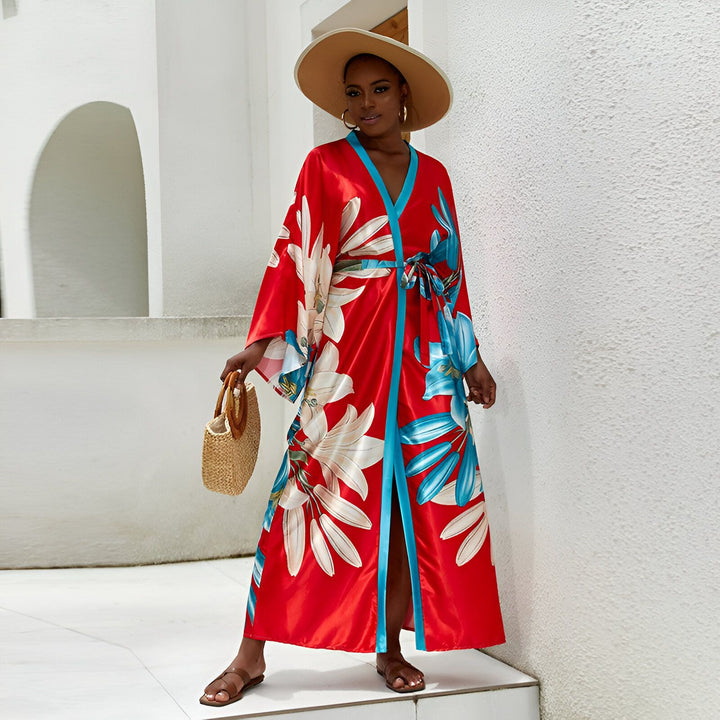 Femme portant un kimono rouge fleuri, chapeau de paille et sac. Élégance estivale. Collection de kimonos. Vêtement de détente ou de plage, style bohème. Boutique en ligne de kimonos.