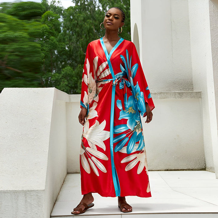 Femme portant un kimono rouge à motifs floraux bleus et blancs. Vêtement d'intérieur élégant, parfait pour la détente ou comme peignoir tendance. Découvrez notre collection de kimonos.