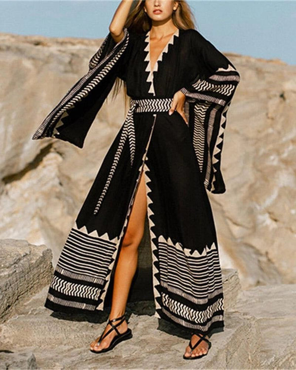 Femme portant un kimono long noir avec motifs blancs, ceinture assortie. Collection de kimonos élégants et confortables. Vêtements d'extérieur style kimono pour femme.
