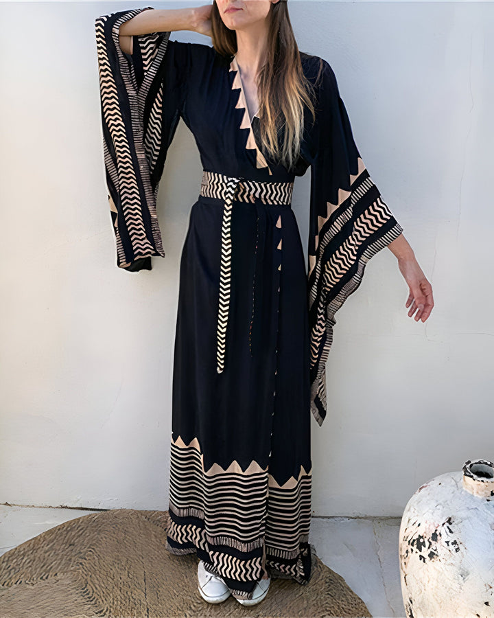 Femme portant un kimono noir à motifs, manches larges et ceinture assortie. Vente de kimonos en ligne.