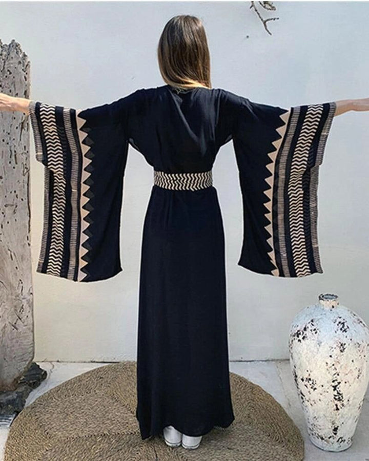 Kimono long noir avec détails ethniques aux manches et ceinture, parfait pour une tenue élégante et confortable. Découvrez notre collection de kimonos uniques.