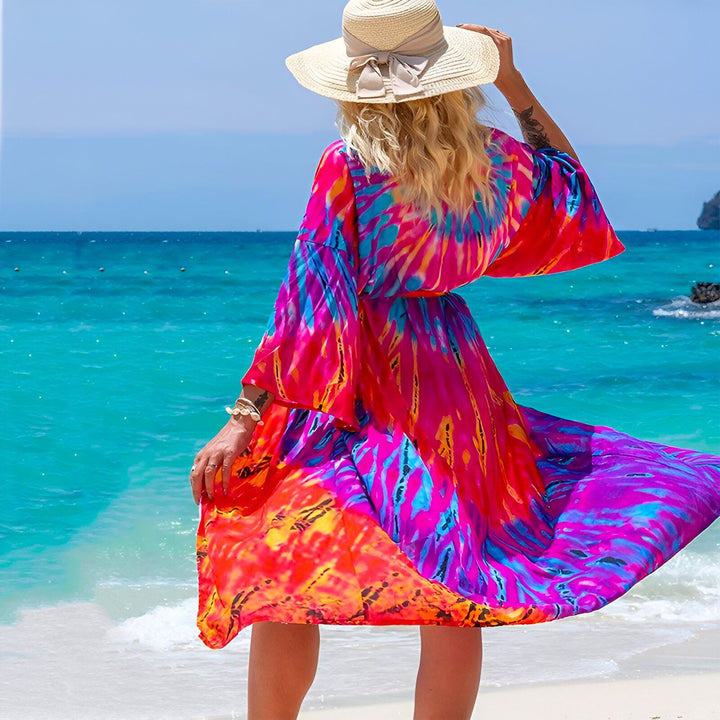Femme portant un kimono coloré sur la plage. Vêtements de plage confortables et élégants. Découvrez notre collection de kimonos pour femmes, parfaits pour les vacances ou pour un look décontracté et tendance. Kimonos disponibles dans une variété de motifs et de couleurs.