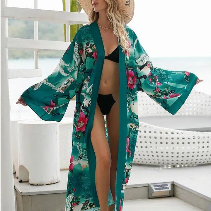 Femme portant un kimono vert à motifs floraux et d'oiseaux. Kimono ample, manches larges. Idéal pour la plage ou la maison. Vêtements de détente. Notre collection de kimonos.
