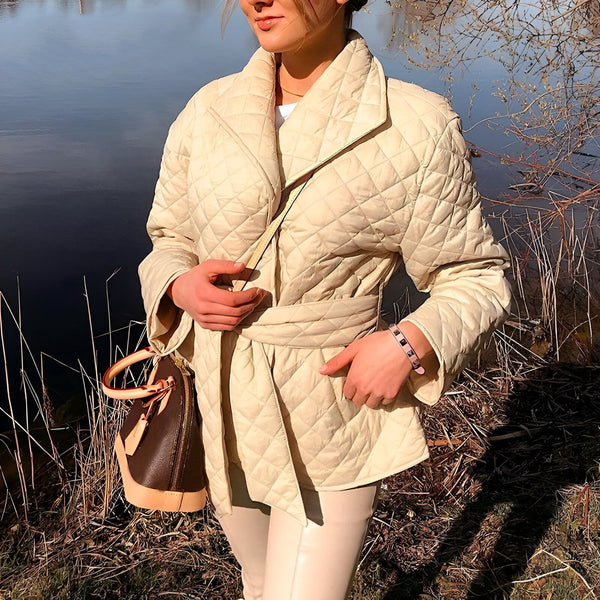 Femme portant un kimono matelassé beige avec ceinture, style décontracté. Kimonos tendance disponibles.