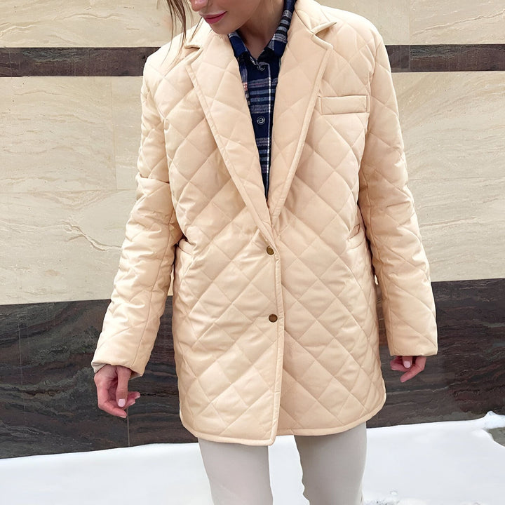 Femme portant une veste matelassée beige, style kimono moderne. Élégance et confort, parfait pour toutes les occasions. Découvrez notre collection de kimonos uniques.