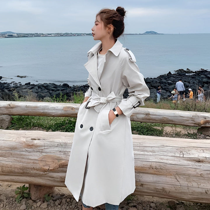 Femme portant un trench-coat kimono crème élégant près de l'océan. Vêtements de style kimono à la mode. Nouvelle collection de kimonos.