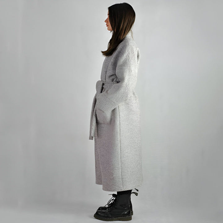 Femme portant un kimono gris long avec une ceinture assortie. Bottes noires. Vêtements de style kimono à la mode.