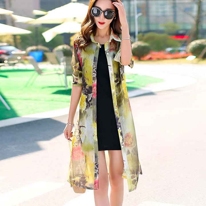 Femme portant un kimono long fleuri jaune et vert avec une robe noire, lunettes de soleil. Vêtements de style japonais. Mode kimono pour femmes.