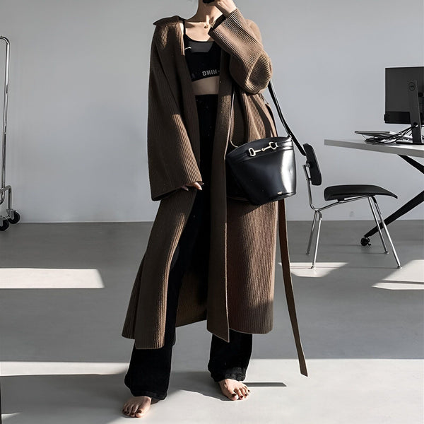 Femme portant un long kimono marron en tricot, un crop top noir, un pantalon noir et un sac à main noir. Vêtements de style kimono à vendre.